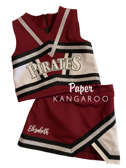 A two-piece cheerleader outfit set consisting of a sleeveless top and a matching skirt, featuring a burgundy, white, and black color scheme with silver glitter trim. The top has 'PIRATES' printed across the chest, and the skirt has 'Elizabeth' embroidered on the side.