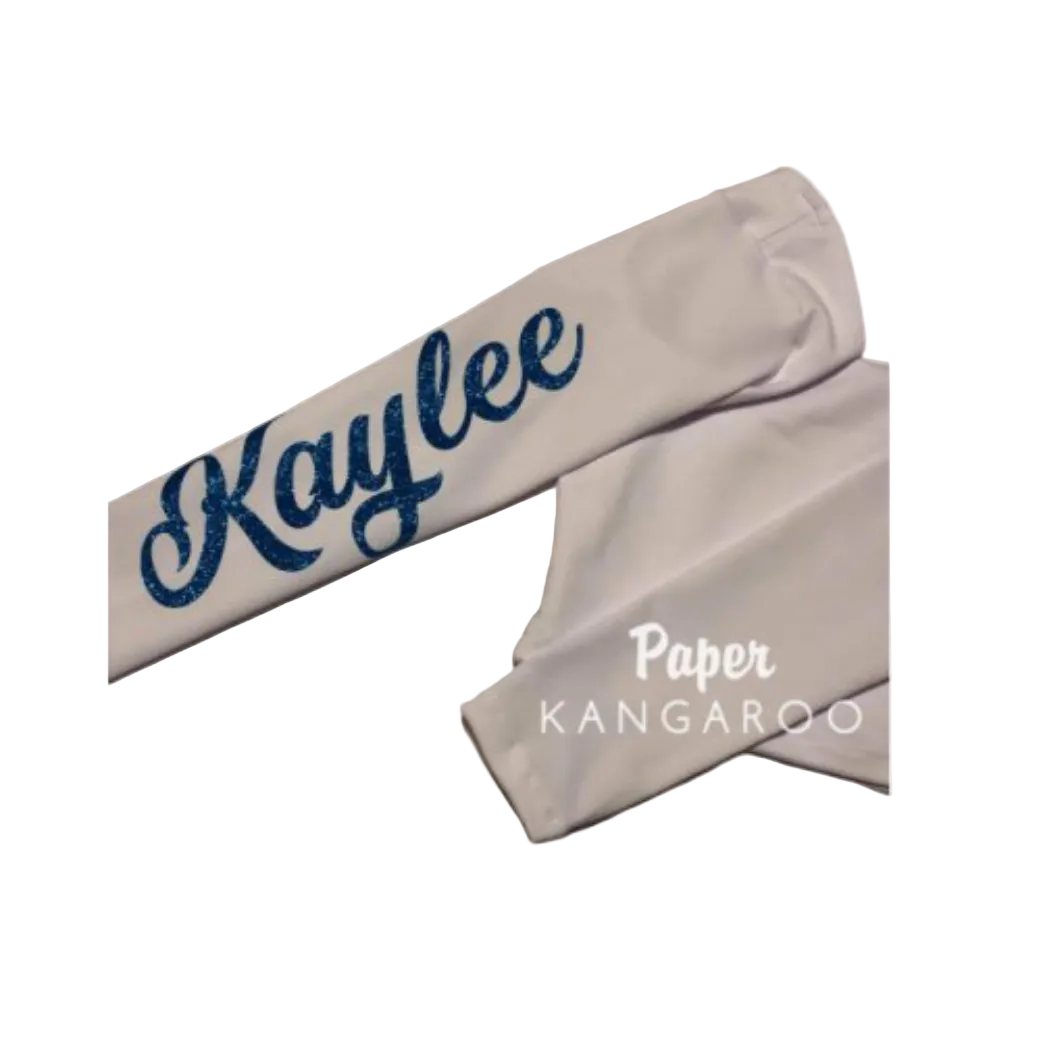 A white fabric arm warmth or sleeve with the name 'Kaylee' printed in dark blue glitter script on one end, and 'Paper KANGAROO' printed in white near the cuff, shown on a plain white background.